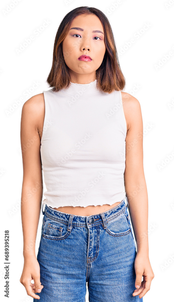 Young beautiful chinese girl wearing casual clothes with serious expression on face. simple and natural looking at the camera. Young beautiful chinese girl wearing casual clothes with serious expression on face. simple and natural looking at the camera.