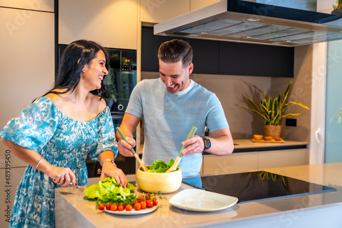 Happy couple in their new home cooking together