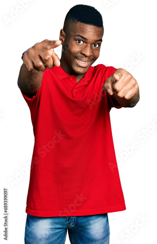 Young african american man wearing casual red t shirt pointing to you and the camera with fingers, smiling positive and cheerful