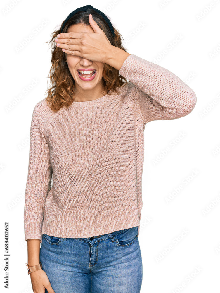 Fototapeta premium Beautiful young caucasian woman wearing casual sweater smiling and laughing with hand on face covering eyes for surprise. blind concept.