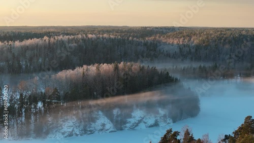 Aerial view to a misty forest landscape in winter above the Nuuksio national park in Finland.  photo