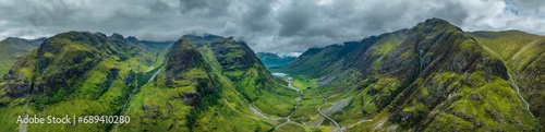Aerial panorama of the prominent mountain range and the three peaks of Three Sisters of Glen Coe, up to 1150 metres high, with the elevated side valley Hidden or Lost Valley on the left and the 953