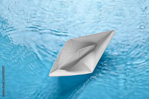 White origami boat on water background