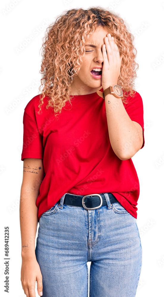 Young blonde woman with curly hair wearing casual red tshirt yawning tired covering half face, eye and mouth with hand. face hurts in pain. Young blonde woman with curly hair wearing casual red tshirt yawning tired covering half face, eye and mouth with hand. face hurts in pain.