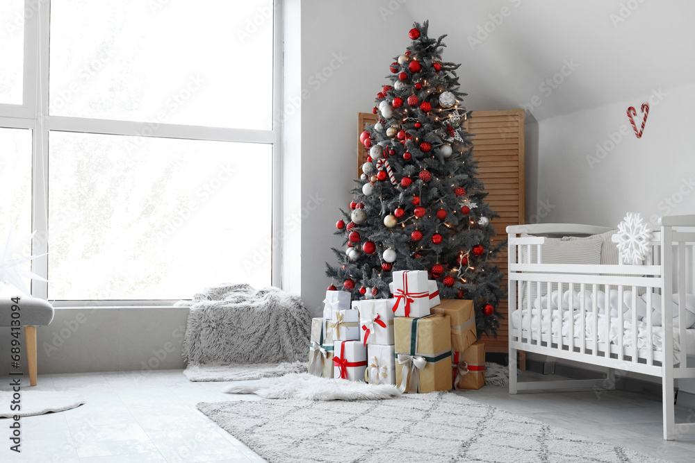 Interior of festive nursery room with decorated Christmas tree and gift boxes Interior of festive nursery room with decorated Christmas tree and gift boxes