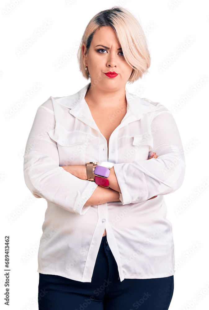 Young blonde plus size woman wearing casual shirt skeptic and nervous, disapproving expression on face with crossed arms. negative person. Young blonde plus size woman wearing casual shirt skeptic and nervous, disapproving expression on face with crossed arms. negative person.