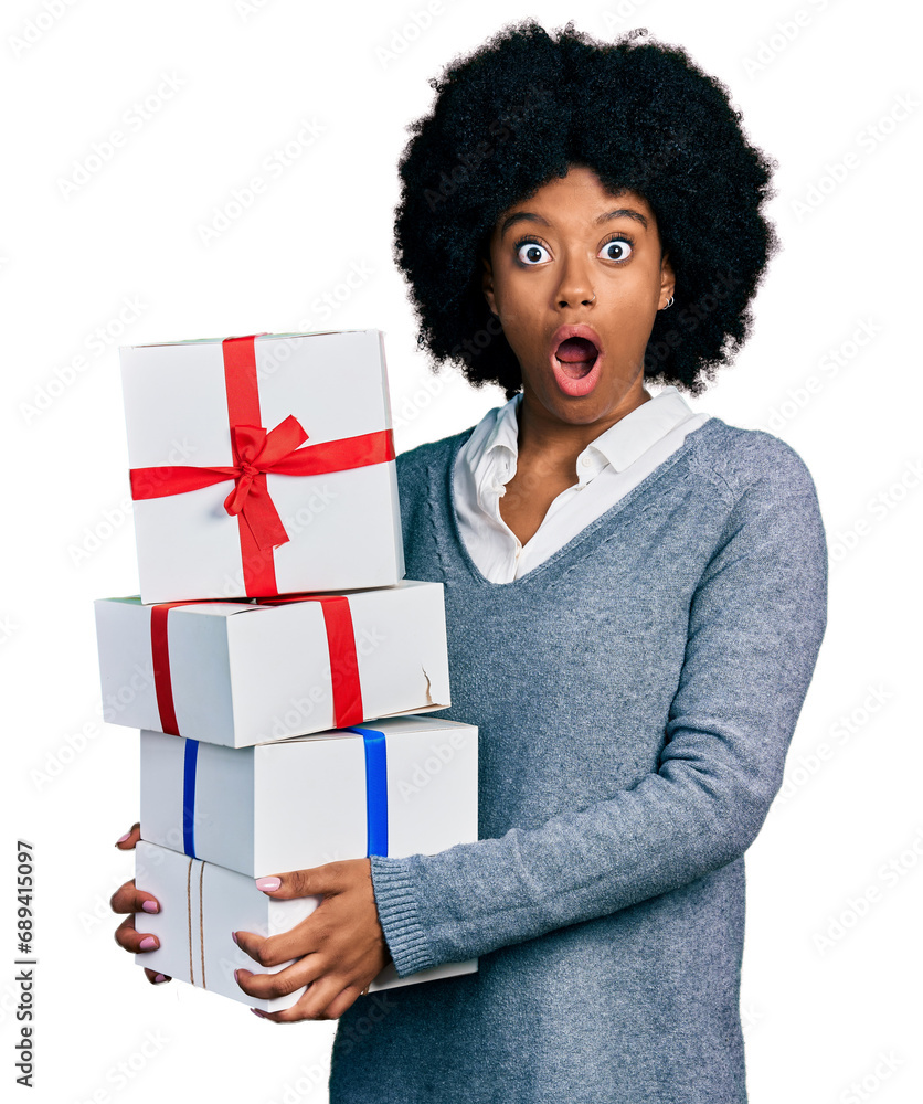 Young african american woman holding gifts afraid and shocked with surprise and amazed expression, fear and excited face. Young african american woman holding gifts afraid and shocked with surprise and amazed expression, fear and excited face.