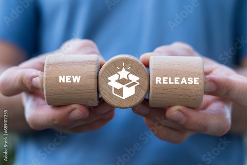 Man holding wooden blocks sees inscription: NEW RELEASE. New release concept. New product development. Coming soon announce. Update product version. photo