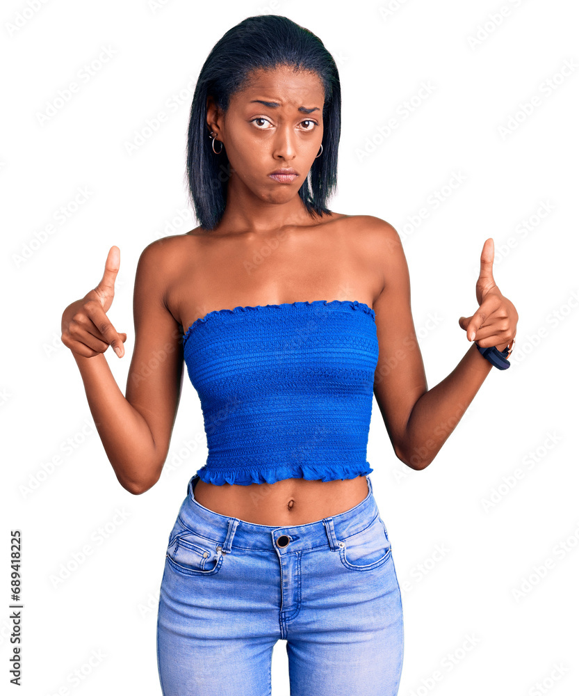 Young african american woman wearing casual summer clothes pointing down looking sad and upset, indicating direction with fingers, unhappy and depressed. Young african american woman wearing casual summer clothes pointing down looking sad and upset, indicating direction with fingers, unhappy and depressed.