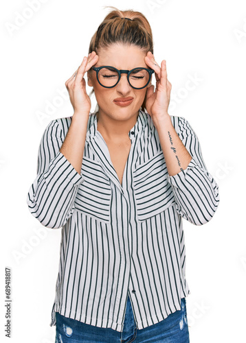 Young caucasian woman wearing business shirt and glasses with hand on head for pain in head because stress. suffering migraine.