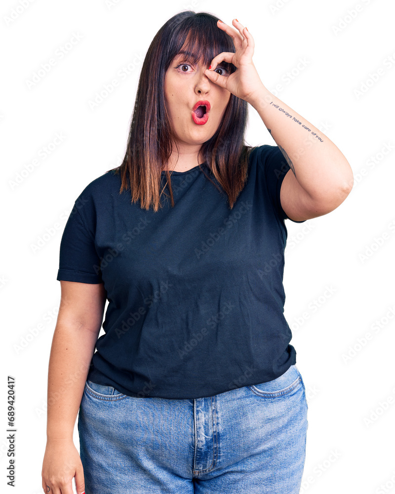 Young plus size woman wearing casual clothes doing ok gesture shocked with surprised face, eye looking through fingers. unbelieving expression. Young plus size woman wearing casual clothes doing ok gesture shocked with surprised face, eye looking through fingers. unbelieving expression.