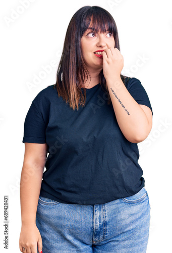 Young plus size woman wearing casual clothes looking stressed and nervous with hands on mouth biting nails. anxiety problem.