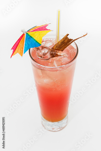 Cocktail with paper umbrella and cinnamon, aerial view.