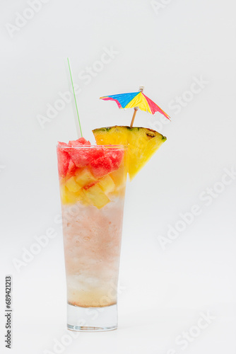 Cocktail drink with pineapple, straw and umbrella isolated on white background.