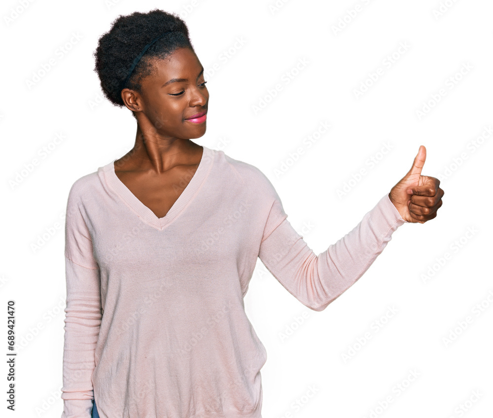 Young african american girl wearing casual clothes looking proud, smiling doing thumbs up gesture to the side Young african american girl wearing casual clothes looking proud, smiling doing thumbs up gesture to the side