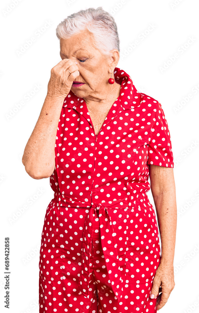Senior beautiful woman with blue eyes and grey hair wearing a red summer dress tired rubbing nose and eyes feeling fatigue and headache. stress and frustration concept. Senior beautiful woman with blue eyes and grey hair wearing a red summer dress tired rubbing nose and eyes feeling fatigue and headache. stress and frustration concept.