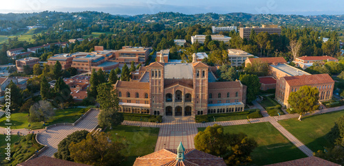 Aerial view of UCLA campus with Royce Hall center stage, Romanesque architecture, green spaces, and Westwood's urban backdrop in golden morning - afternoon light. photo