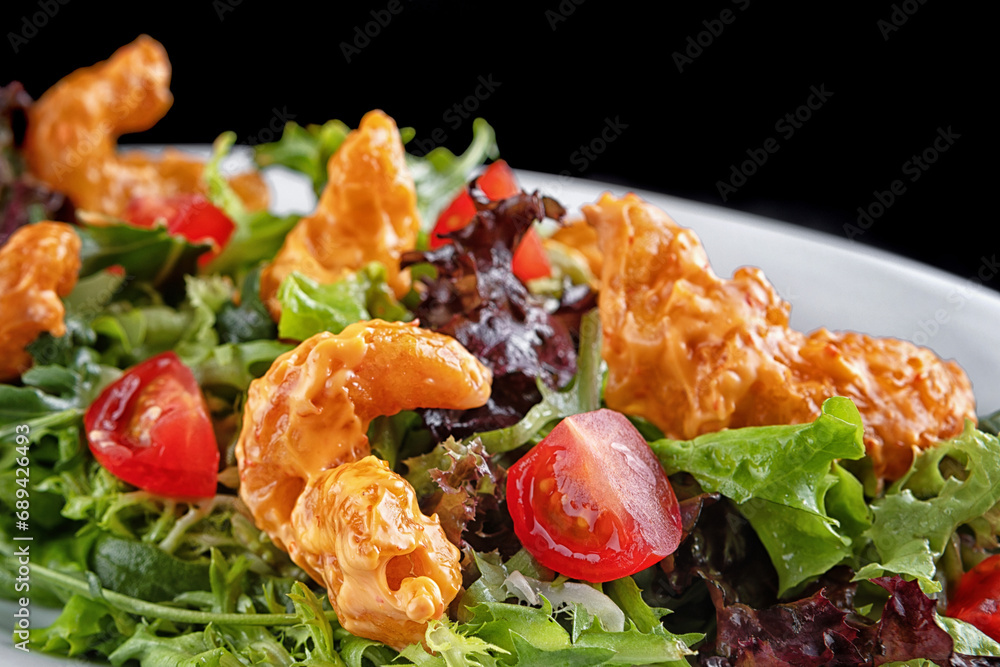 Salad with shrimp in batter, herbs and tomatoes on a plate Salad with shrimp in batter, herbs and tomatoes on a plate