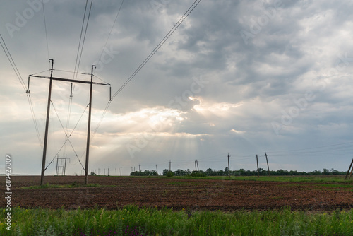 scenery of power lines and sunlight shedding from the cloudy sky in the Donbass region of eastern Ukraine photo