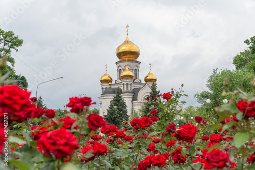 St. Michael's church and red rose flower bed in pokrovsk city of donetsk oblast photo