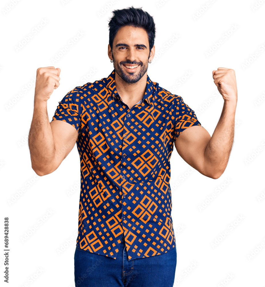 Handsome hispanic man wearing casual clothes screaming proud, celebrating victory and success very excited with raised arms Handsome hispanic man wearing casual clothes screaming proud, celebrating victory and success very excited with raised arms