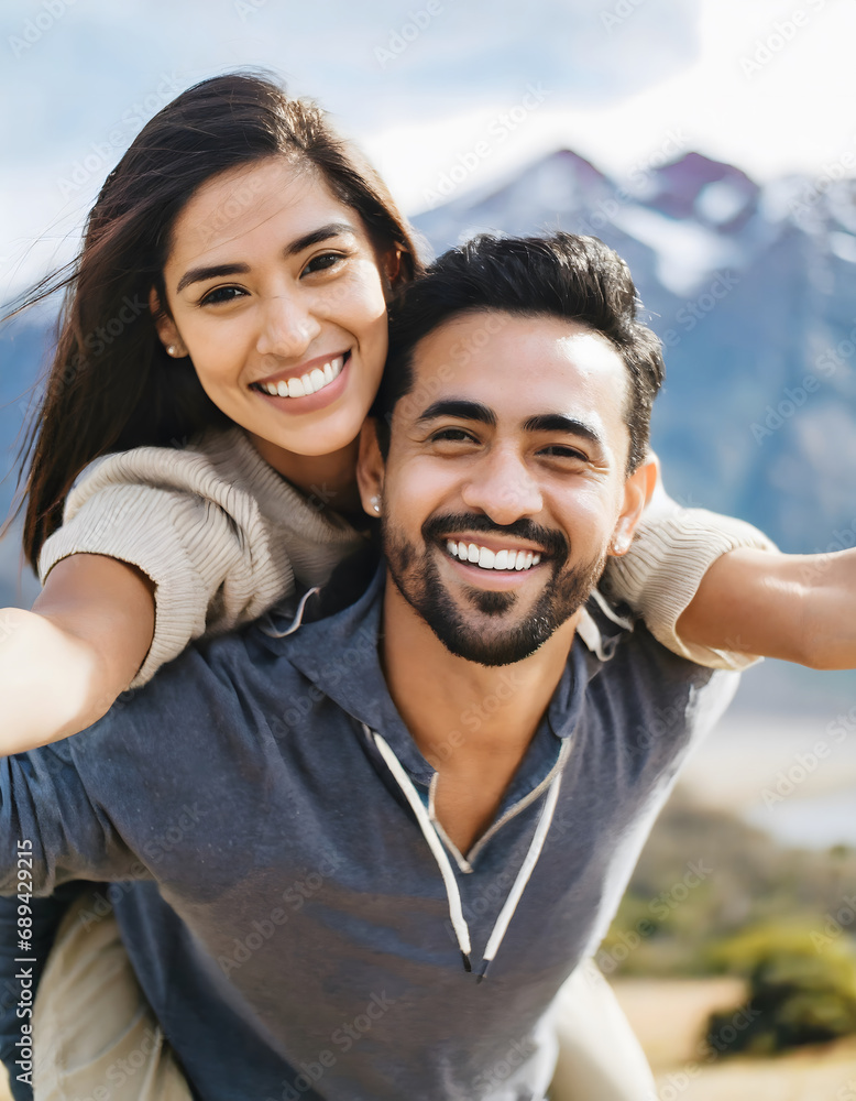 Obraz premium cheerful young adult couple on vacation in mountains, woman leans on man's back while they open arms, vacation concept, happy valentines day