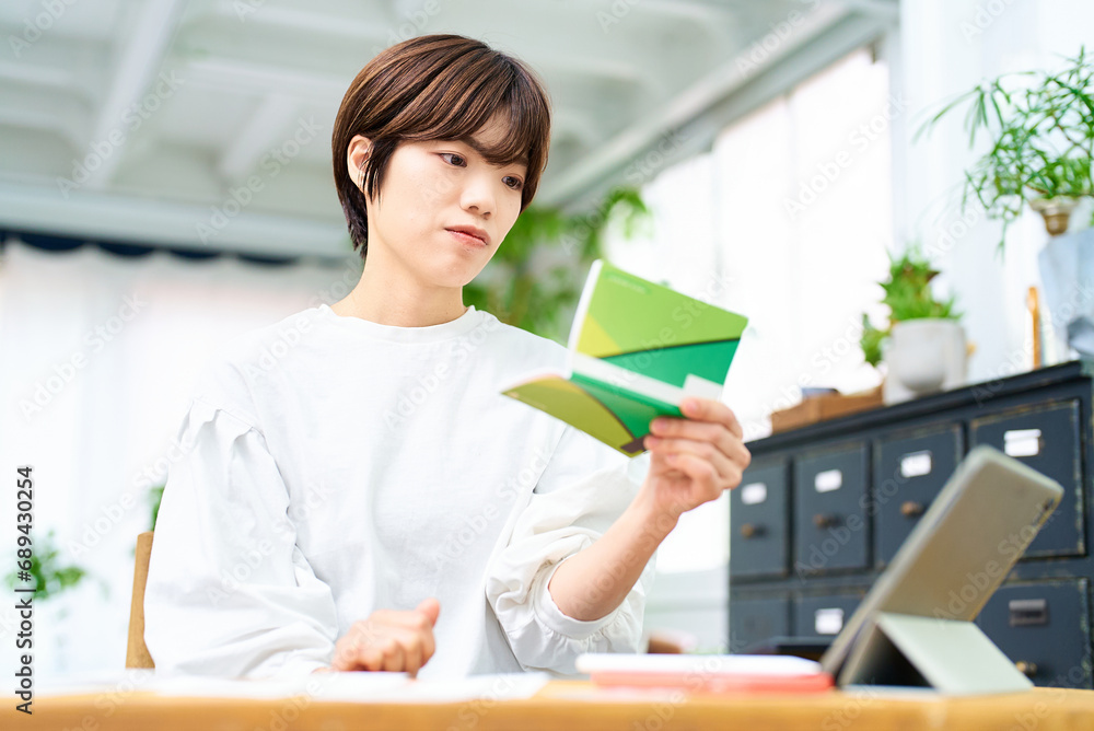 通帳を眺める若い女性 通帳を眺める若い女性