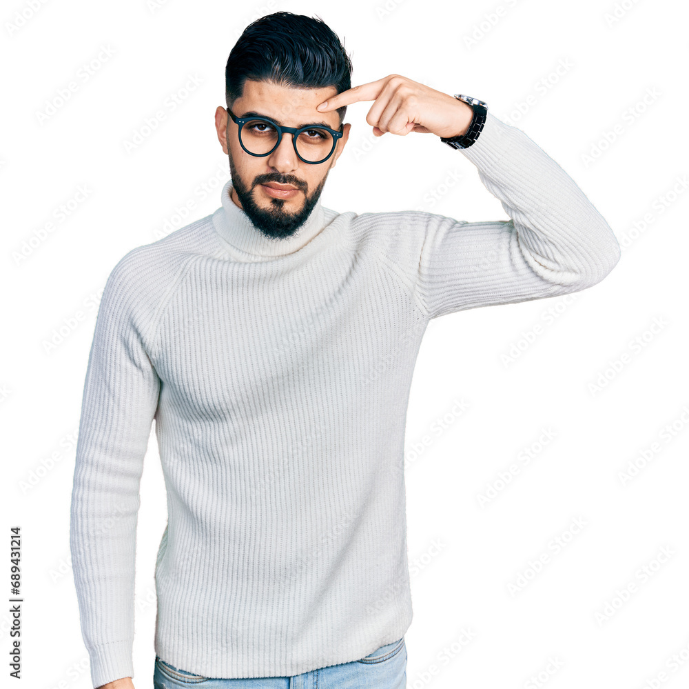 Young arab man with beard wearing elegant turtleneck sweater and glasses pointing unhappy to pimple on forehead, ugly infection of blackhead. acne and skin problem Young arab man with beard wearing elegant turtleneck sweater and glasses pointing unhappy to pimple on forehead, ugly infection of blackhead. acne and skin problem