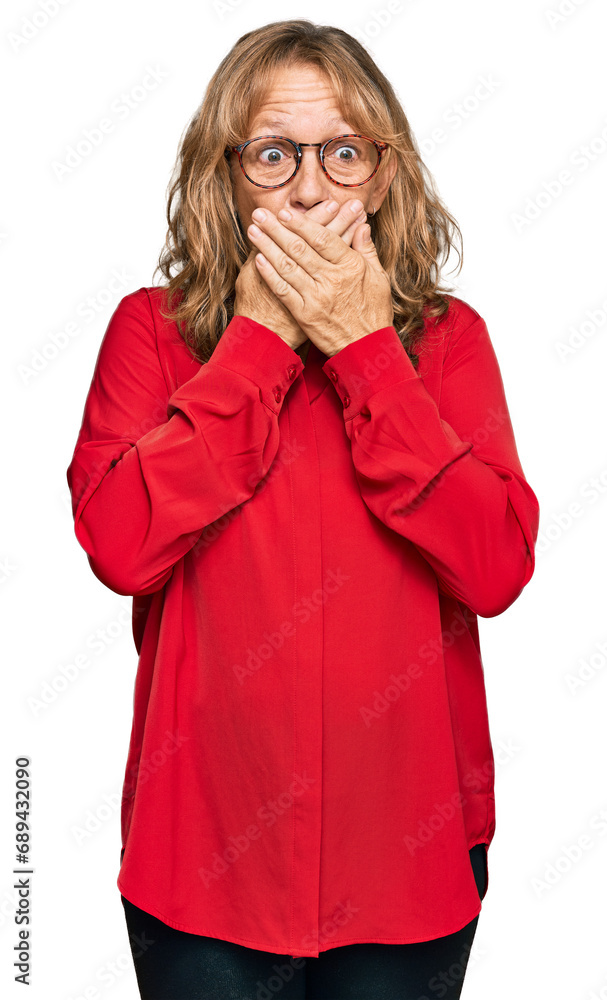 Middle age blonde woman wearing casual shirt over red background shocked covering mouth with hands for mistake. secret concept. Middle age blonde woman wearing casual shirt over red background shocked covering mouth with hands for mistake. secret concept.