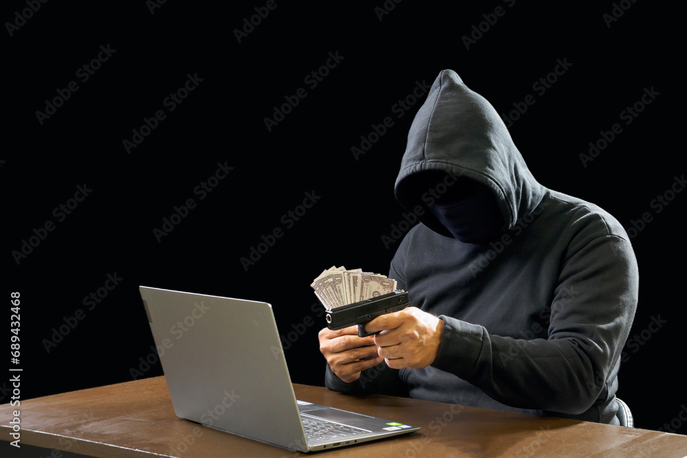 Hacker spy man wearing a black shirt, sitting on a chair and a table, is a thief, hands holding money, counting the amount obtained from hijacking or robbing, in a pitch-black room. Hacker spy man wearing a black shirt, sitting on a chair and a table, is a thief, hands holding money, counting the amount obtained from hijacking or robbing, in a pitch-black room.