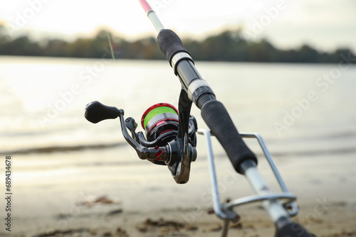 Fishing rod with reel near river, closeup