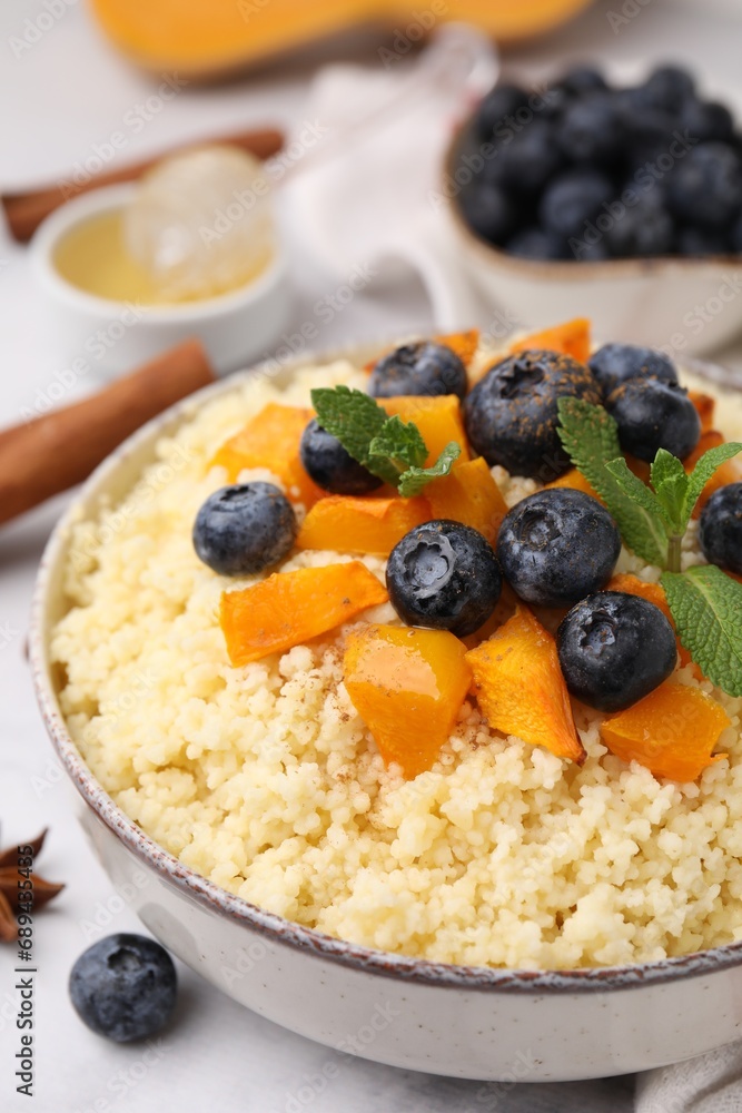 Bowl of tasty couscous with blueberries, pumpkin and mint on table, closeup Bowl of tasty couscous with blueberries, pumpkin and mint on table, closeup