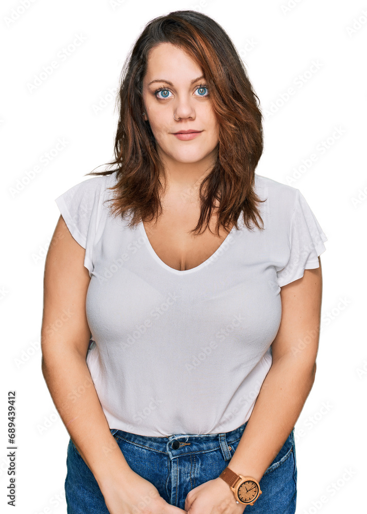 Young plus size woman wearing casual white t shirt relaxed with serious expression on face. simple and natural looking at the camera.