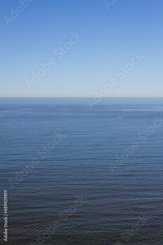 Small ship sails in quiete water of pacific ocean with blue sky in California coast Usa, America