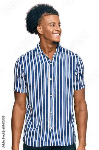 African american man with afro hair wearing casual clothes looking away to side with smile on face, natural expression. laughing confident.
