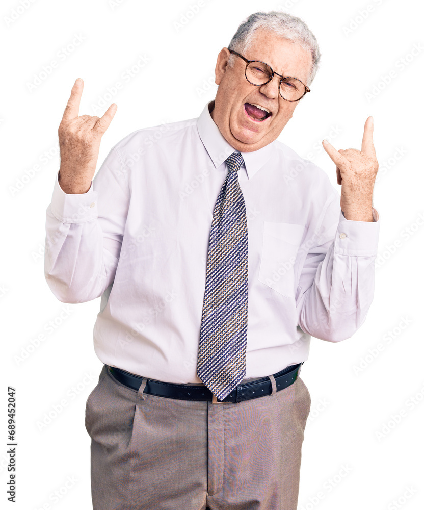 Senior grey-haired man wearing business clothes shouting with crazy expression doing rock symbol with hands up. music star. heavy concept. Senior grey-haired man wearing business clothes shouting with crazy expression doing rock symbol with hands up. music star. heavy concept.