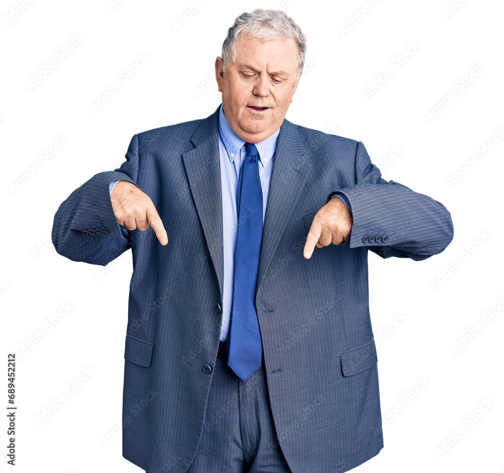 Senior grey-haired man wearing business jacket pointing down with fingers showing advertisement, surprised face and open mouth Senior grey-haired man wearing business jacket pointing down with fingers showing advertisement, surprised face and open mouth