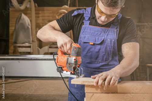 A carpenter using a jigsaw to cut wood cuts bars. Home repair concepts, close up.