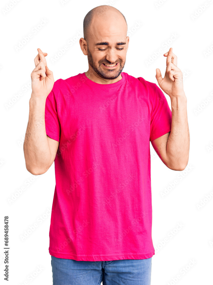 Fototapeta premium Young handsome man wearing casual t shirt gesturing finger crossed smiling with hope and eyes closed. luck and superstitious concept.
