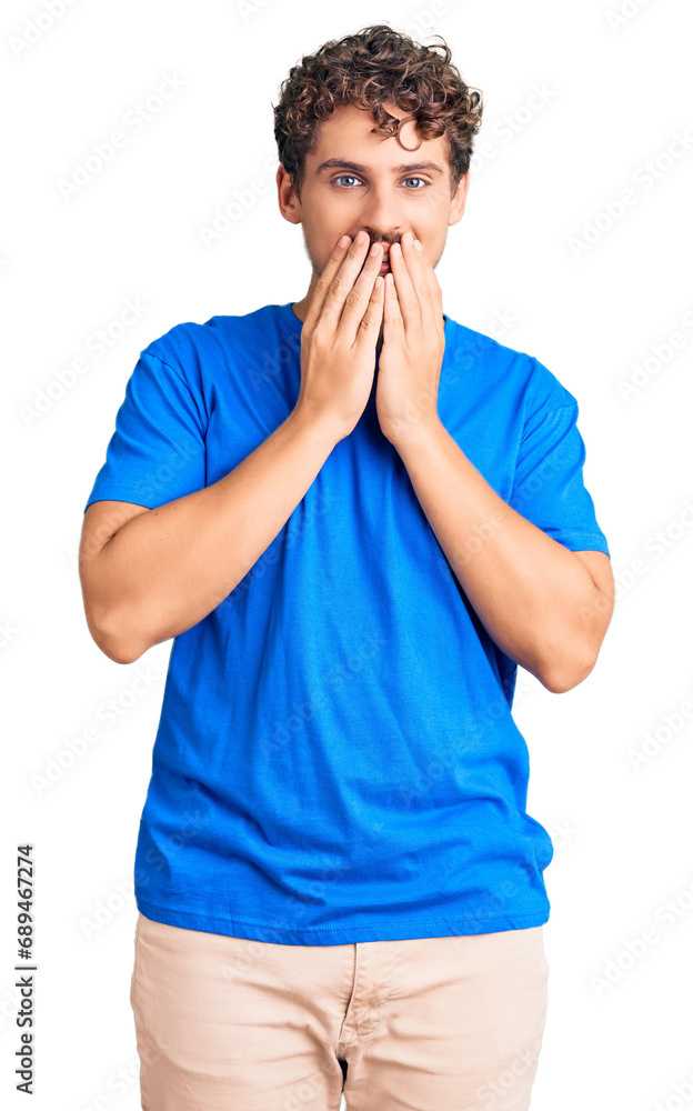 Young handsome man with curly hair wearing casual clothes laughing and embarrassed giggle covering mouth with hands, gossip and scandal concept Young handsome man with curly hair wearing casual clothes laughing and embarrassed giggle covering mouth with hands, gossip and scandal concept