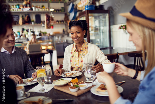 Diverse group of young friends enjoying mean in cozy restaurant photo