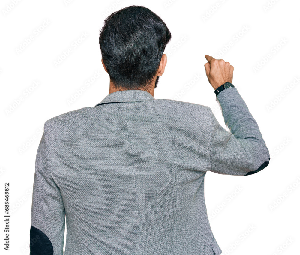 Young hispanic man wearing business clothes posing backwards pointing ahead with finger hand