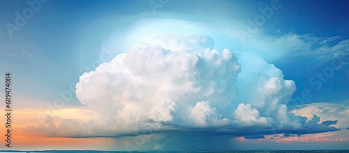 Dominican Republic's tropical sky displays a dominant cumulonimbus cloud on a sunny afternoon, with a powerful rainstorm and thunderstorm, creating a vertical mushroom cloud in a blue sky.