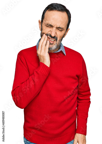 Middle age hispanic man wearing casual clothes touching mouth with hand with painful expression because of toothache or dental illness on teeth. dentist