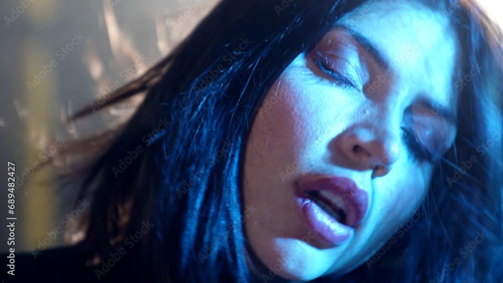 woman gangster taking off black balaclava from her beautiful face, closeup portrait