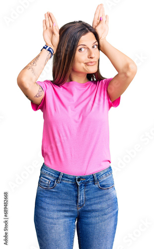 Beautiful caucasian woman wearing casual clothes doing bunny ears gesture with hands palms looking cynical and skeptical. easter rabbit concept.