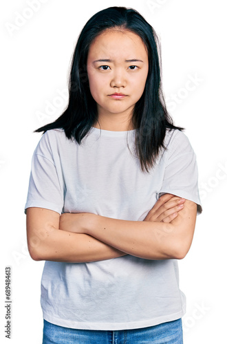 Young chinese woman wearing casual white t shirt skeptic and nervous, disapproving expression on face with crossed arms. negative person. © Krakenimages.com