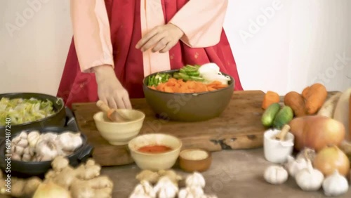 Close-up of a Korean woman wearing a traditional hanbok, she making Kimchi.