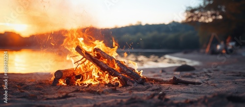 Fire no longer burning on the sand. Used fire on the shore. Fire no longer burning. Burnt wood fire by the river. photo