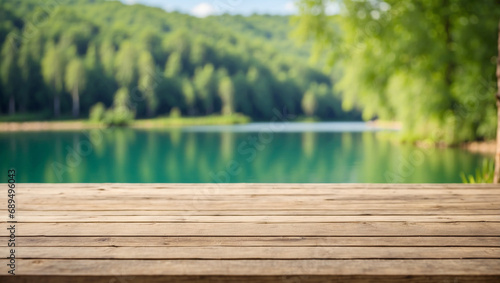 Empty wooden table top with blurred background of lake forest. There are trees in the green background.